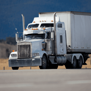 Long-haul tractor-trailer traveling on a clear day along a rural highway